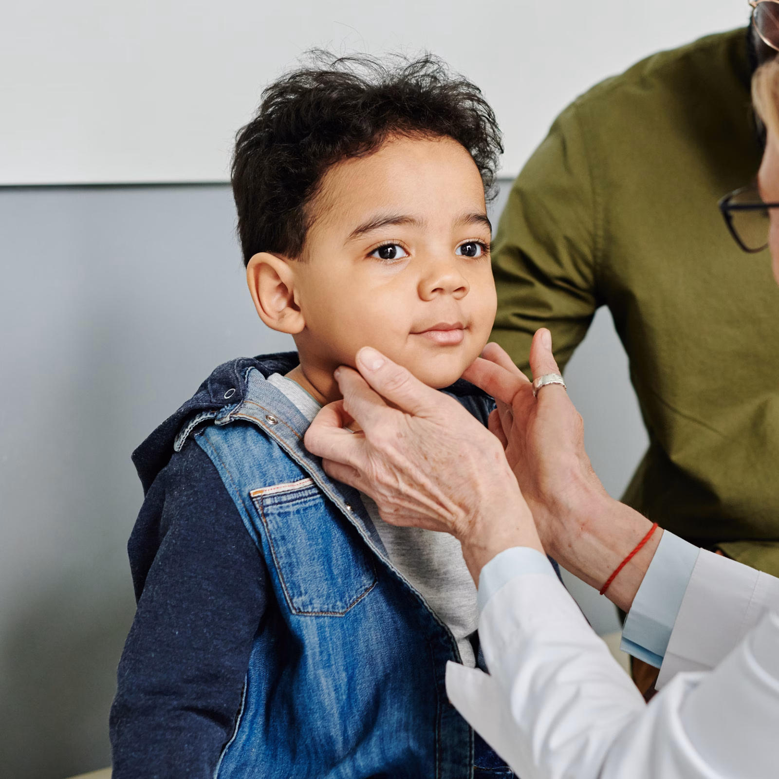 Doctor Checking Neck Of Young Boy